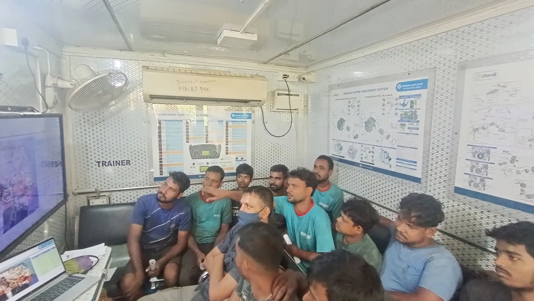 Trainees seated inside a mobile training unit around a display screen